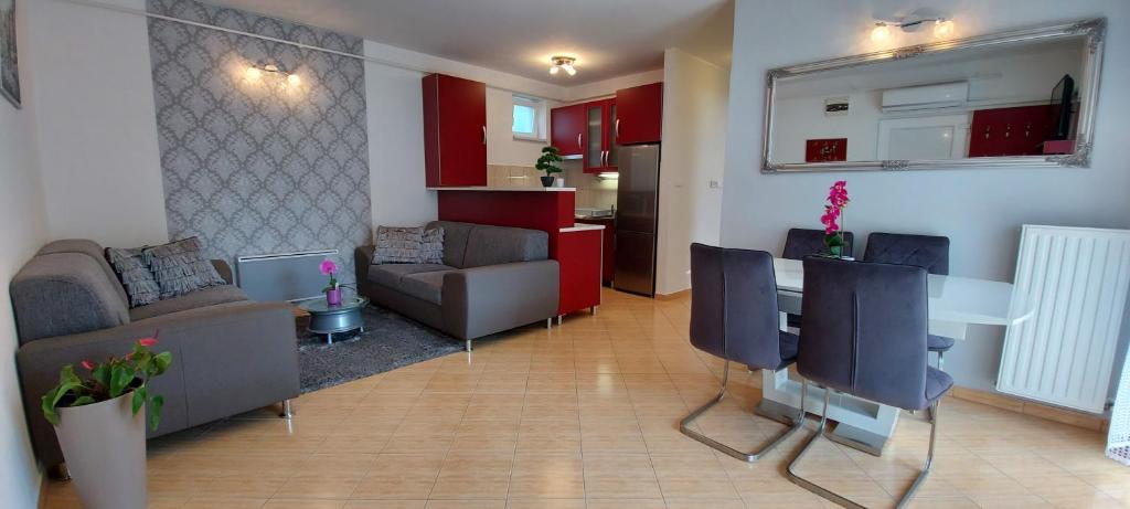 een woonkamer met een bank en een tafel met stoelen bij Amulett Suite Apartment in Hajdúszoboszló