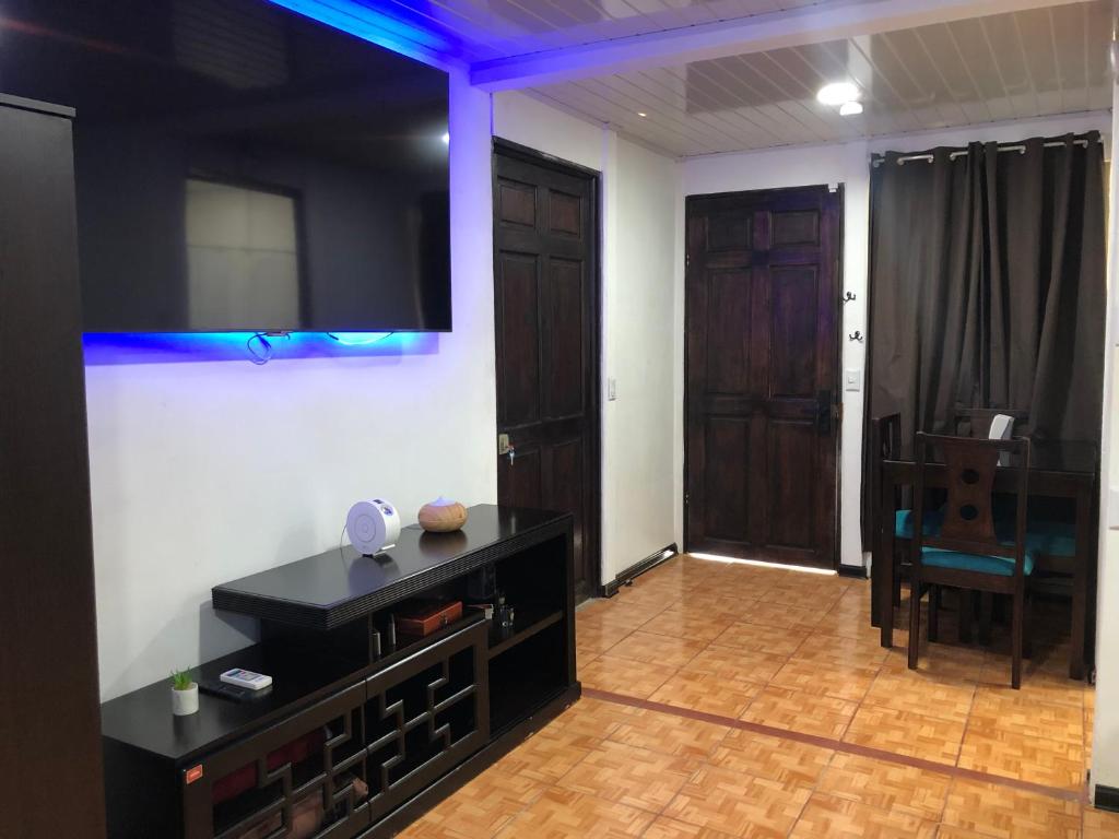 uma sala de estar com uma televisão de ecrã plano na parede em Comodo Departamento full equipado con cocina, TV 80p, wifi 150mbs, etc em Paquera