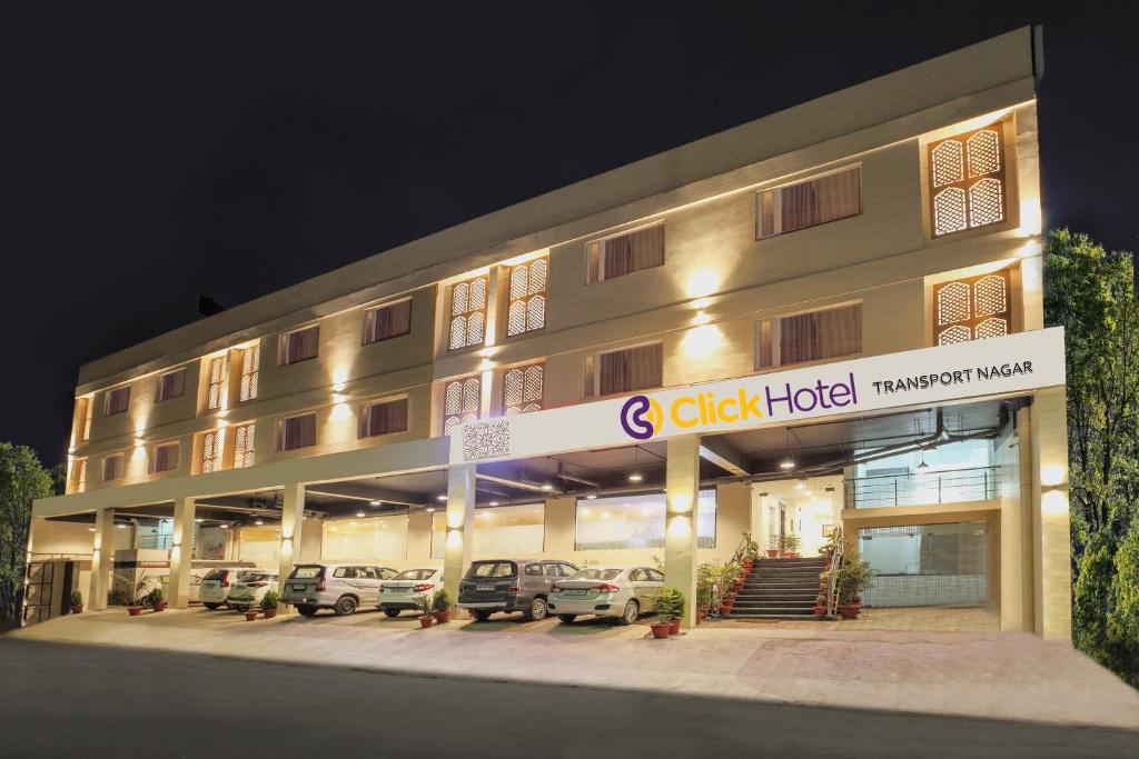 un hôtel avec des voitures garées à l'extérieur le soir dans l'établissement Click Hotel Transport Nagar, à Lucknow