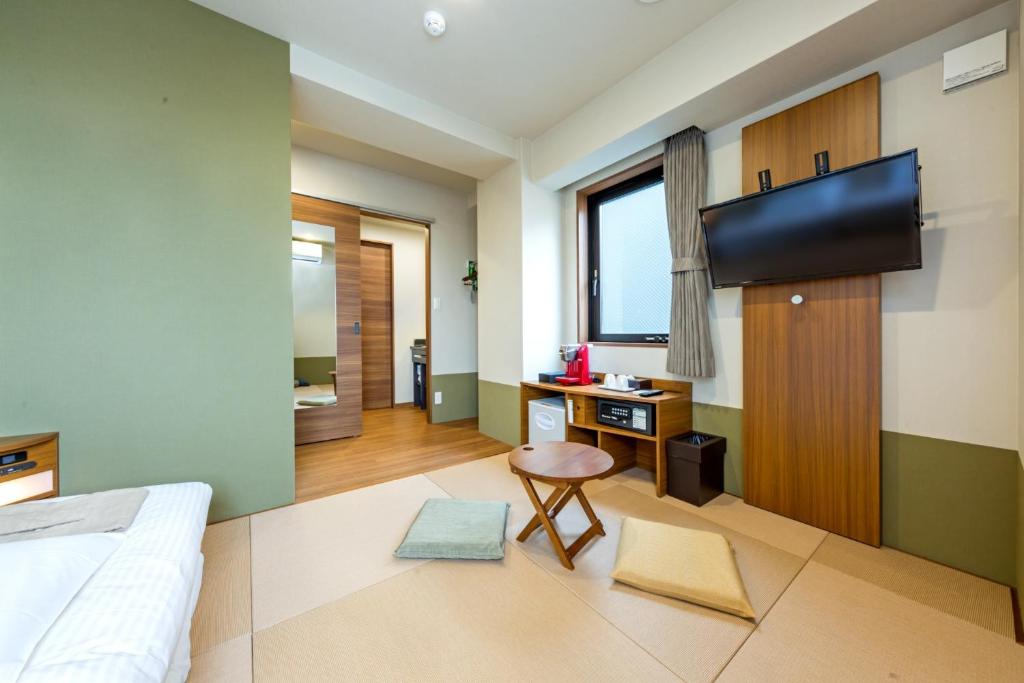 a bedroom with a bed and a desk and a television at Hotel Meldia Shijo Kawaramachi - Vacation STAY 86747 in Kyoto
