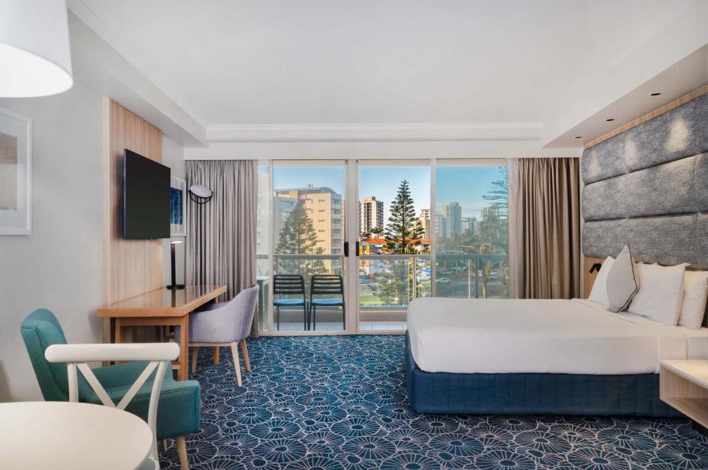a hotel room with a bed and a large window at The Sebel Twin Towns in Gold Coast