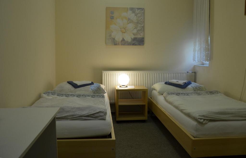 2 camas en una habitación con una mesa y una lámpara en Penzion Duo, en Mladá Boleslav