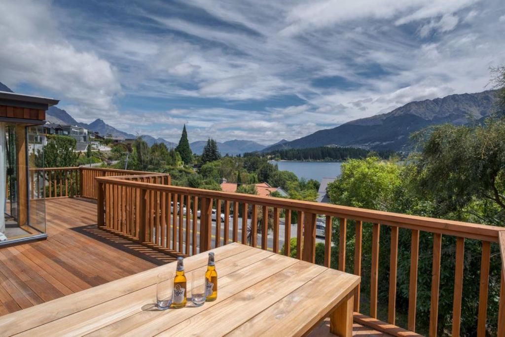 a wooden deck with two bottles of beer on a table at The Lakehouse in Queenstown