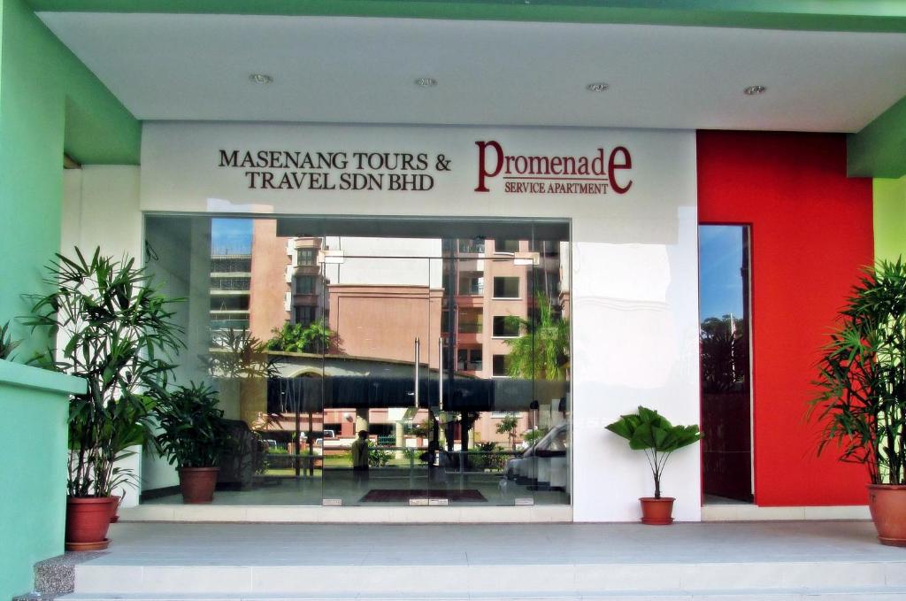 un edificio con un cartel que lee viajes enmascarados y gestiona el final taminés en Promenade Service Apartment, en Kota Kinabalu