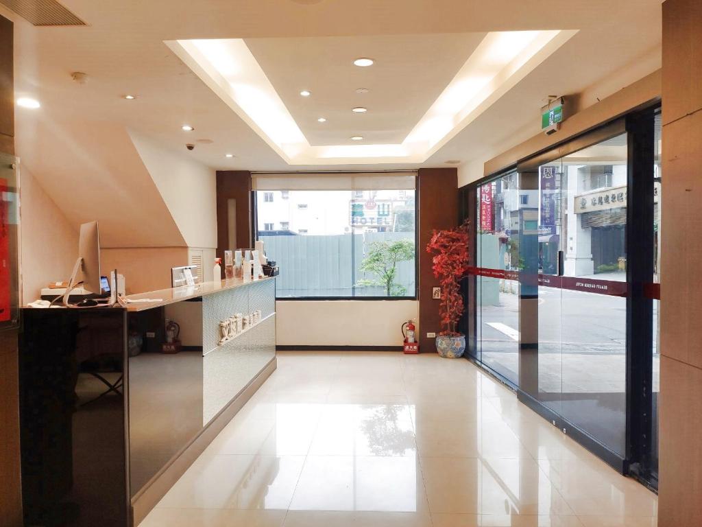 a lobby with a desk and a large window at Ashare Hotel in Jiaoxi