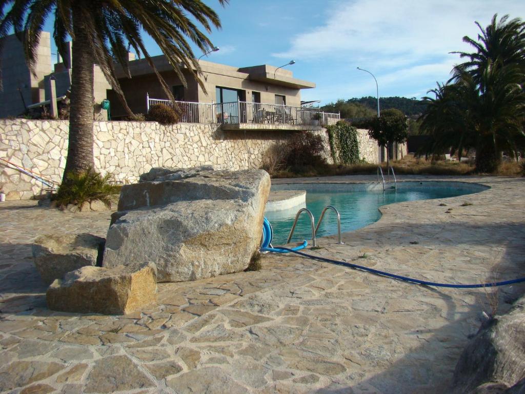 a swimming pool with a blue hose next to a house at Can Clapa in Les Borges del Camp