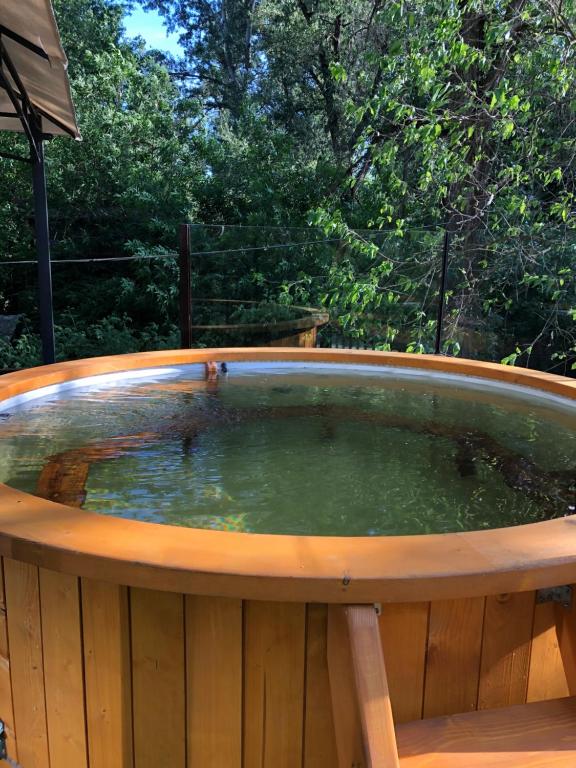 a hot tub on a wooden deck with water in it at Bárka a Tiszához apartman in Tiszaug