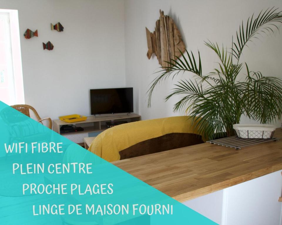 uma sala de estar com uma mesa de madeira com uma planta em Le Gîte de l'Amer - T2 - Duplex - Centre Bourg em Baden