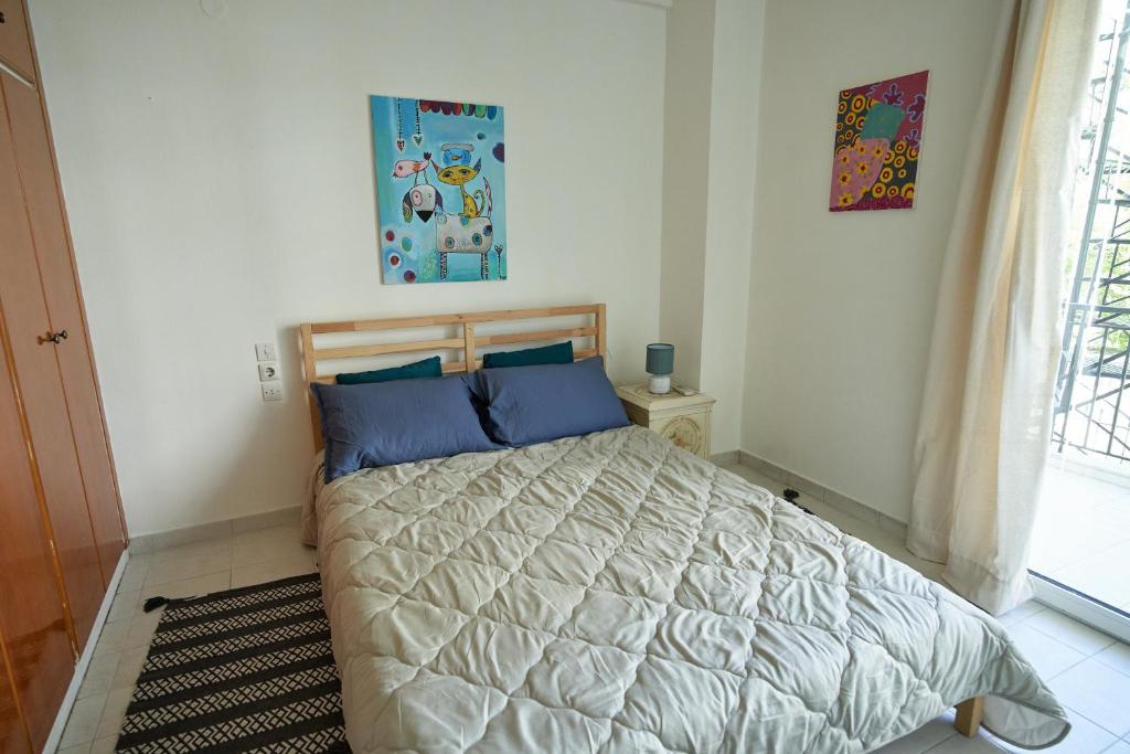 a bedroom with a large bed with blue pillows at Μονοκατοικία στο κέντρο με τζάκι in Patra