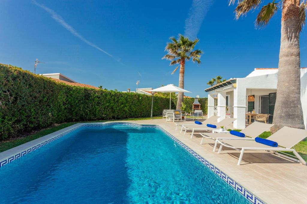 a swimming pool with lounge chairs and a house at Villa Juanes in Ciutadella