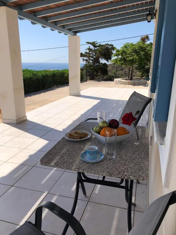 a table with a bowl of fruit on a patio at BAY VIEW STUDIO in Megas Gialos - Nites
