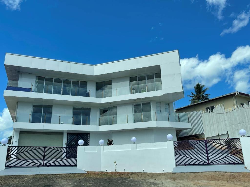 a white building with a blue sky in the background at AYDIZ APARTMENTS in Nadi