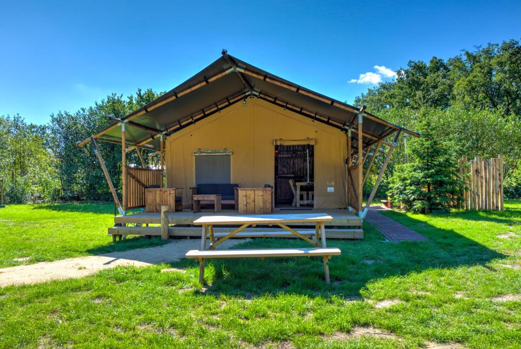 uma mesa de piquenique em frente a uma tenda amarela em Buitenplaats Gerner em Dalfsen