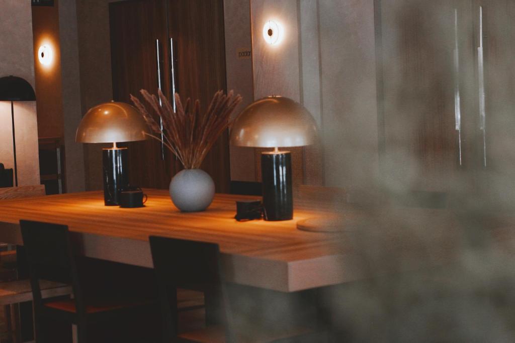 two lamps on a wooden table with chairs at The Brunei Hotel in Bandar Seri Begawan