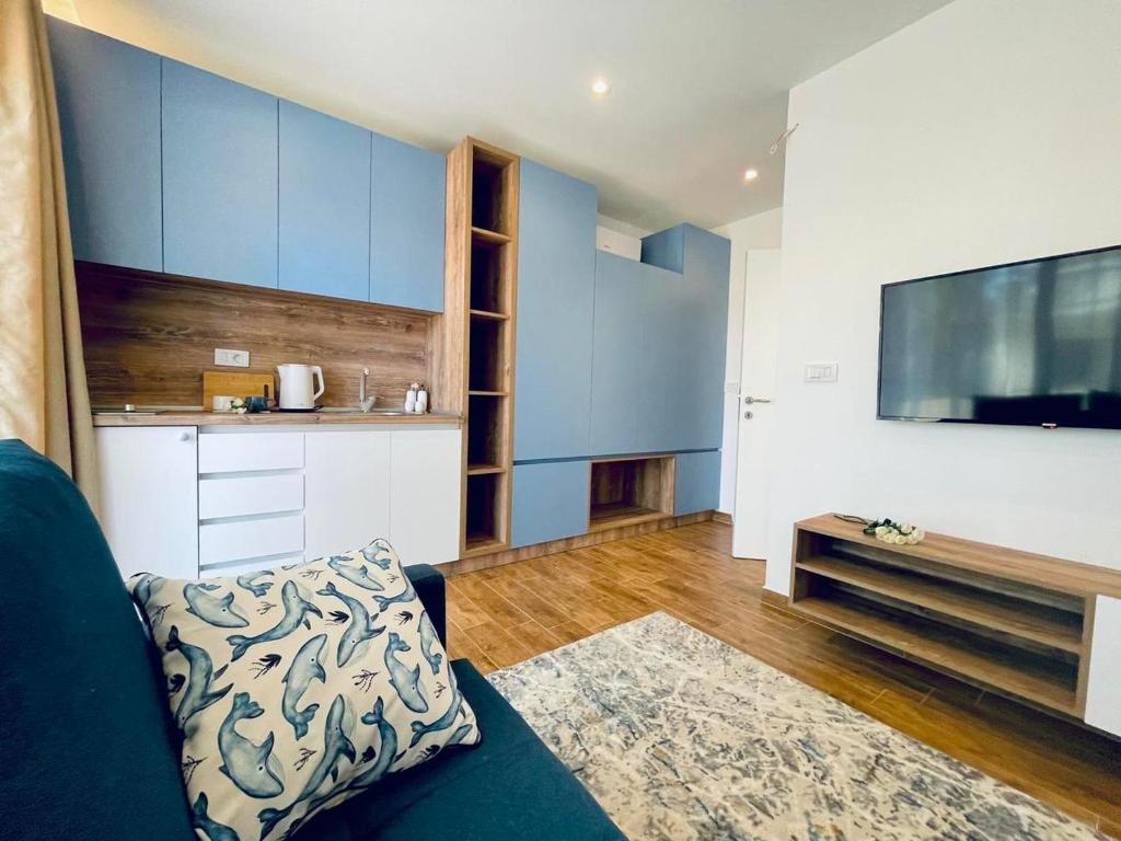 sala de estar con paredes azules y blancas y sofá en Garden Villas, en Donji Štoj