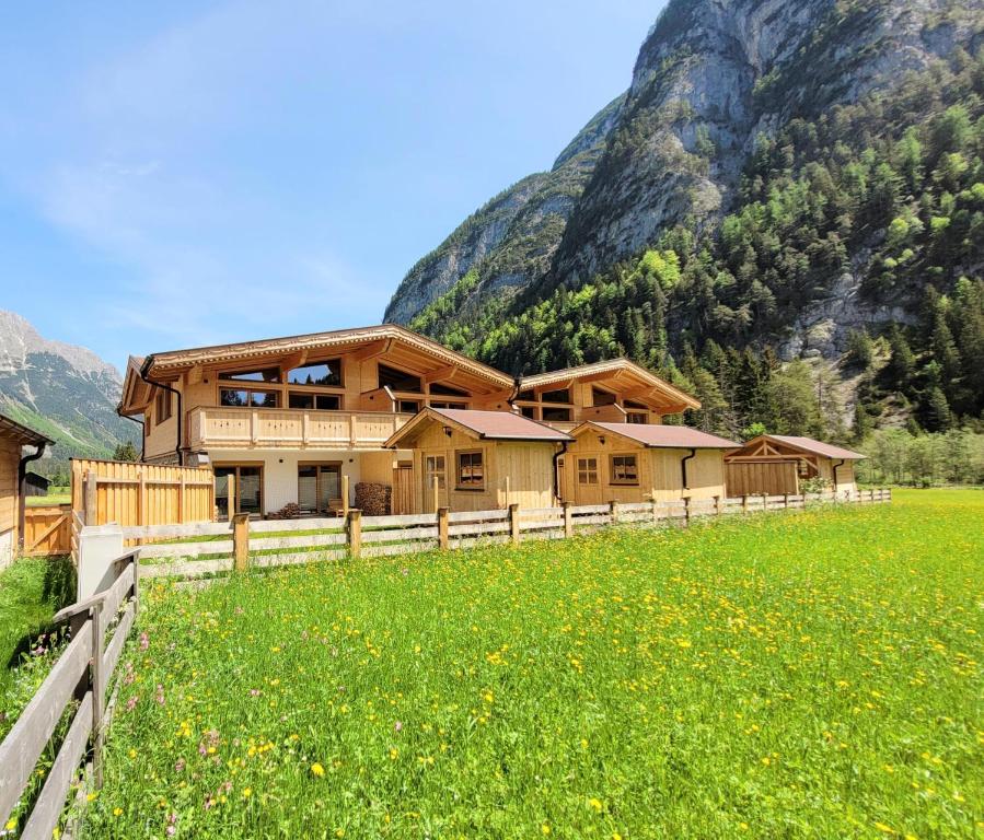 a house in a field in front of a mountain at Puitbach Chalet in Leutasch