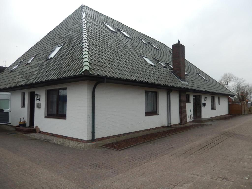 a white house with a black roof at Landhaus Katharina in Westerdeichstrich