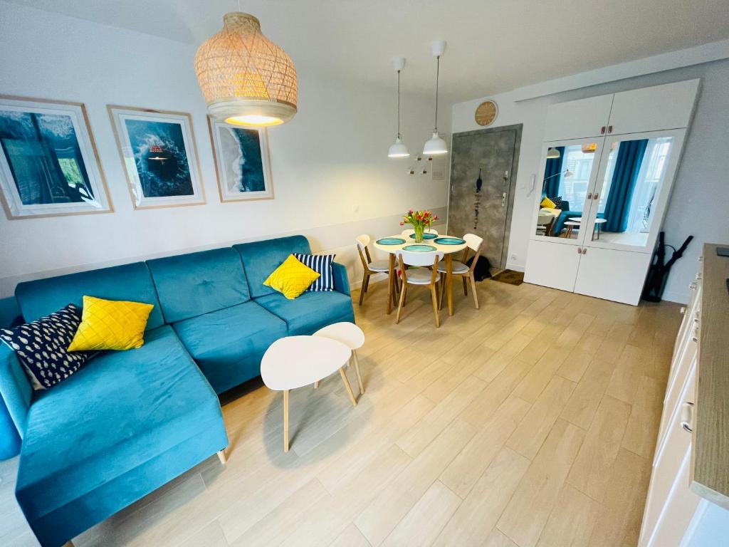 salon z niebieską kanapą i stołem w obiekcie Apartament Baltic A8 Pobierowo w Pobierowie
