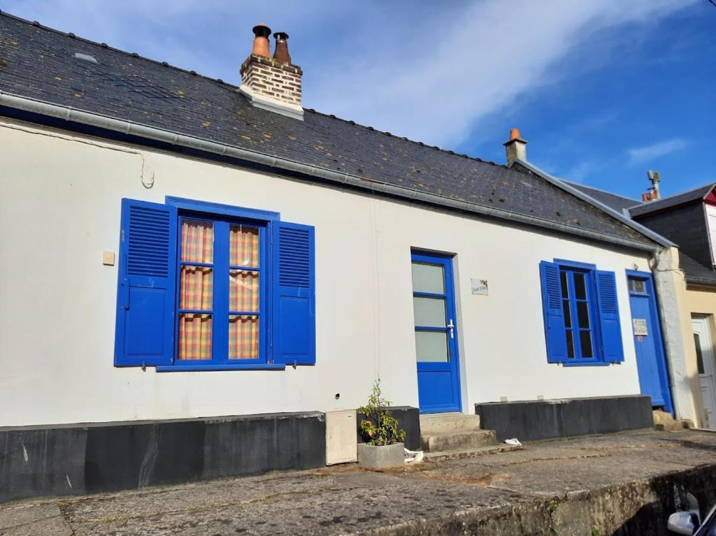 a white house with blue shutters and a chimney at St Elme, maison de pêcheurs, WIFI jardin in Ault