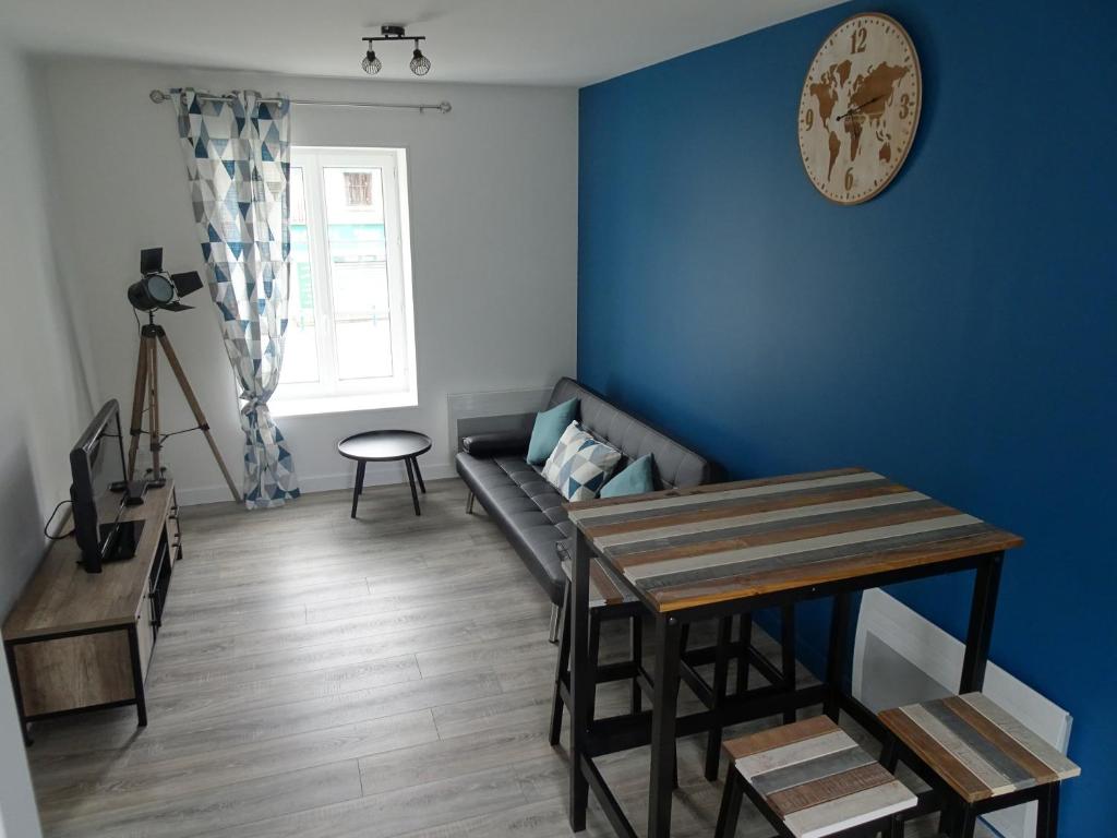 a living room with a couch and a table at Appartement Petite Auberge in Saint-Jean-dʼAssé