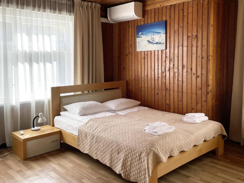 奈達的住宿－Poilsio namai, Rasytė，一间卧室配有一张床,上面有两条毛巾