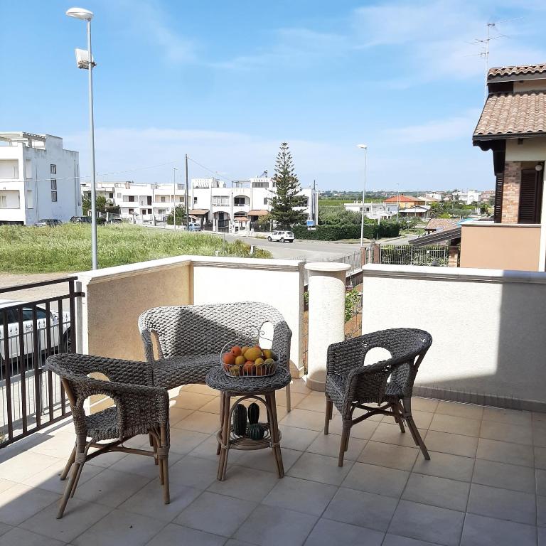 a balcony with two chairs and a table with fruit on it at Stè Sweet home M&A in Scanzano