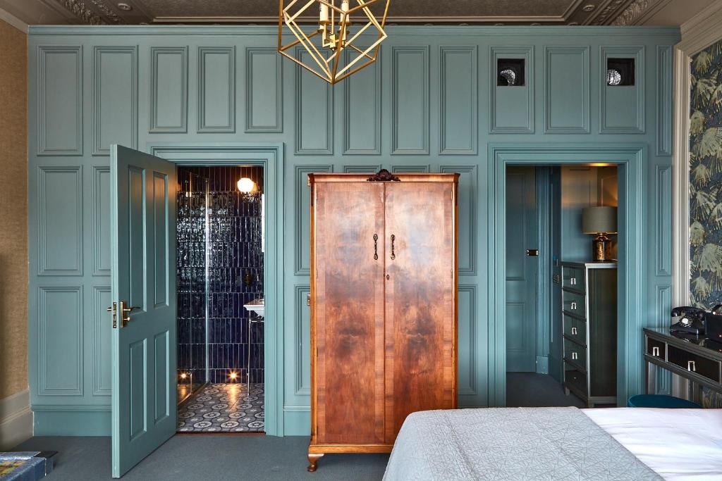 ein Schlafzimmer mit blauen Wänden und einer Holztür in der Unterkunft No17 The Promenade in Oban