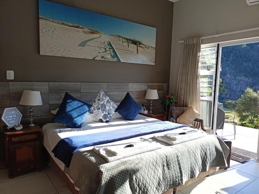 a bedroom with a large bed with blue pillows at Mackenzies Accommodation in East London