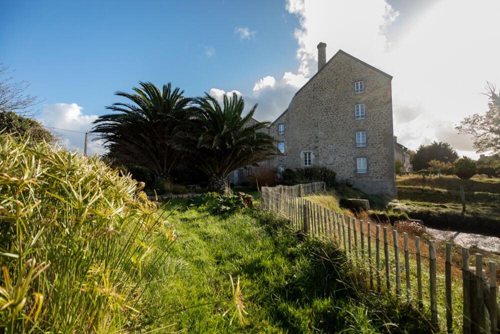 una vecchia casa in pietra con una recinzione di fronte di LE MOULIN DU COUFFON a Kerlouan