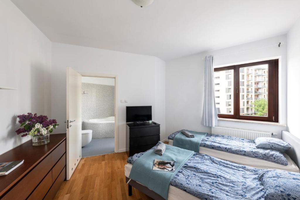 a bedroom with two beds and a window at Waw pokoje Wilanów in Warsaw