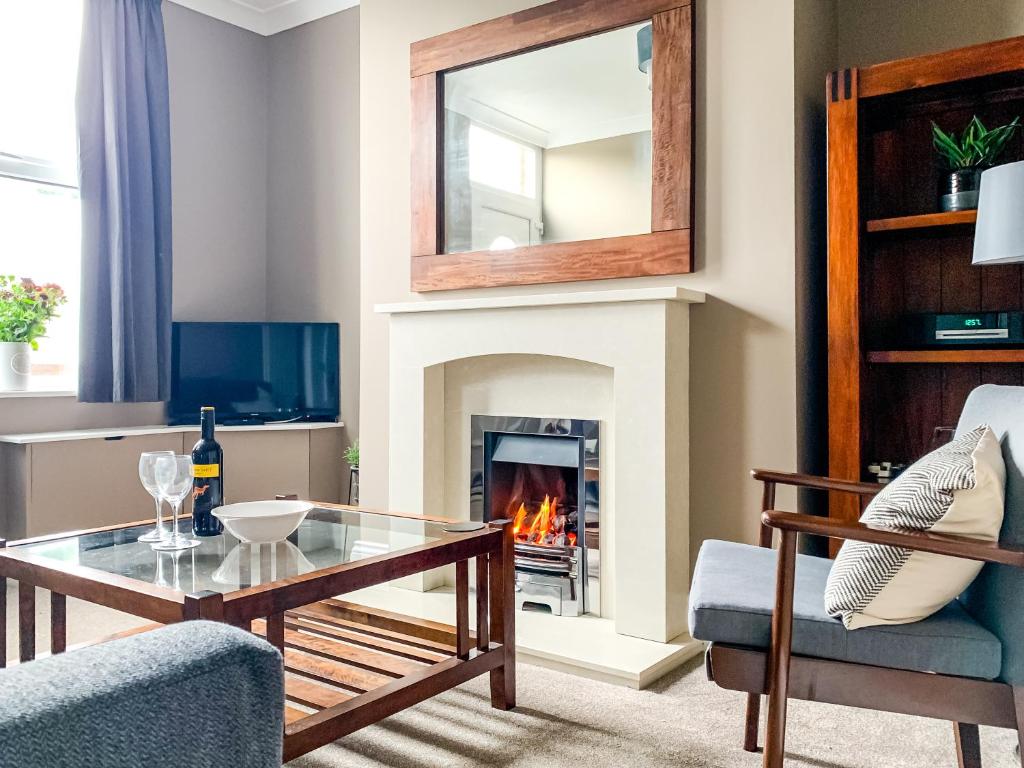a living room with a fireplace and a glass table at Maple House - Free Parking - Holiday Home - Sleeps 12 With Sister Property in York