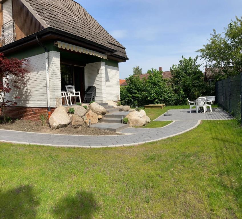 een patio met een tafel en stoelen in een tuin bij Haus Muschelnest in Sahlenburg