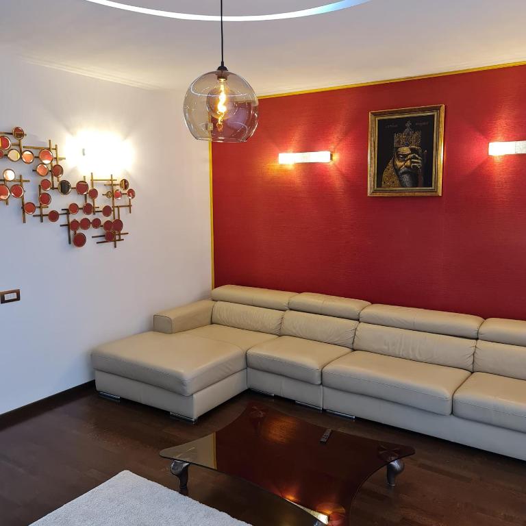 een woonkamer met een bank en een rode muur bij White Galaxy Villa in Otopeni