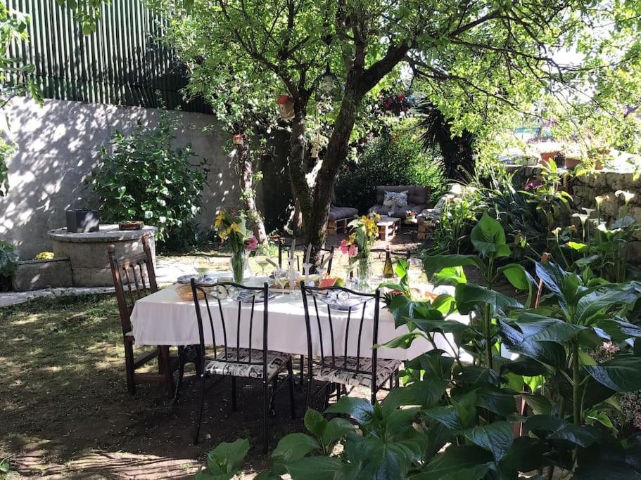 uma mesa e cadeiras num jardim com uma mesa e uma árvore em HyP - La Casa de la Abuela Victoria em Arcade