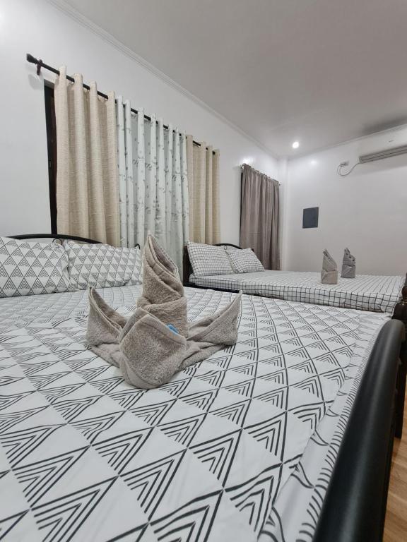 - une chambre avec 2 lits et des oreillers dans l'établissement Kdc Homes, à Puerto Princesa