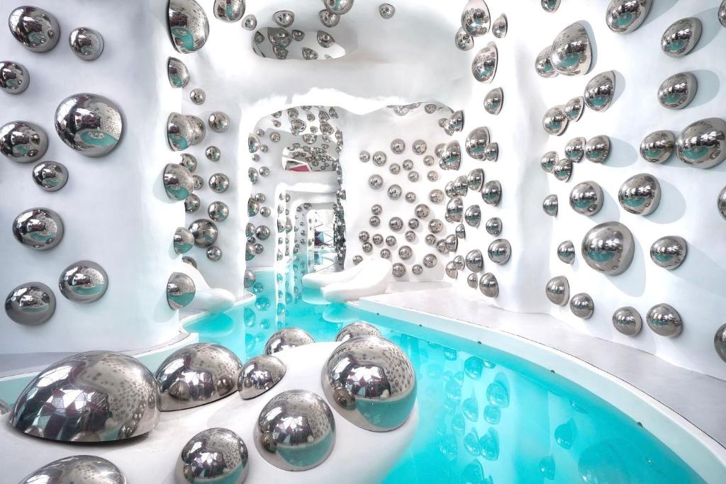 a room with a bunch of silver balls on a wall at Arte Plus KL By Rainbow in Kuala Lumpur