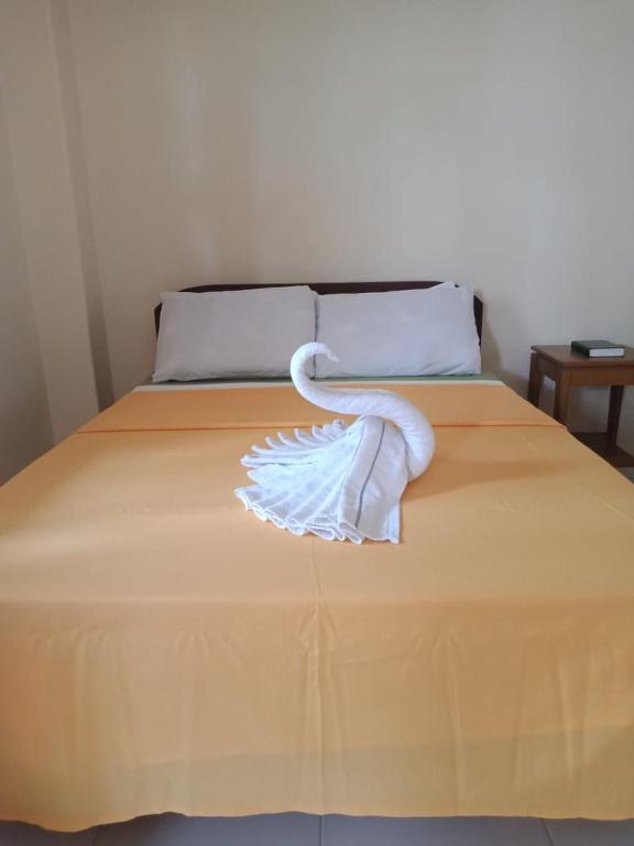 a white swan towel sitting on top of a bed at Villa Almedilla Pension House in Panglao Island