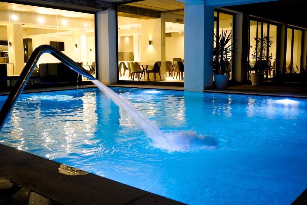 uma fonte de água numa piscina em Hôtel Lescure Business and SPA em Tunes