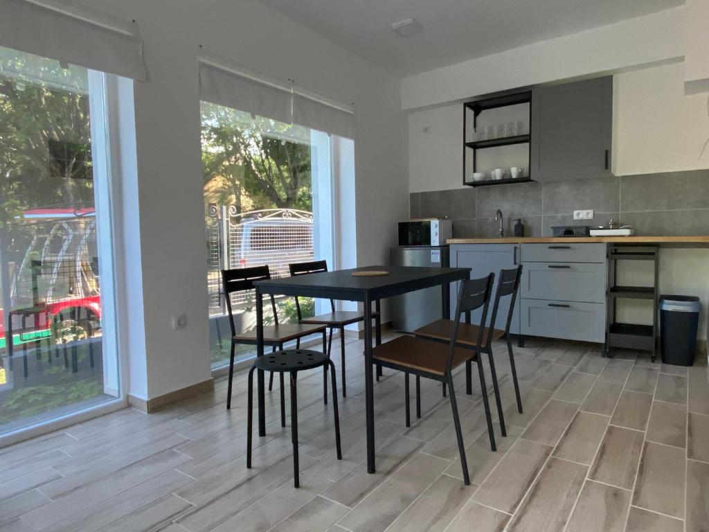 kuchnia ze stołem i krzesłami w pokoju w obiekcie BIKE & FUN Apartments - Balatonakarattya w mieście Balatonakarattya