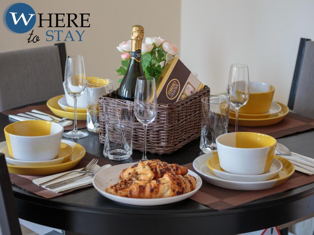 einen Tisch mit einem Teller Essen und einer Flasche Wein in der Unterkunft Ocean Way Apartment in Leith in Edinburgh