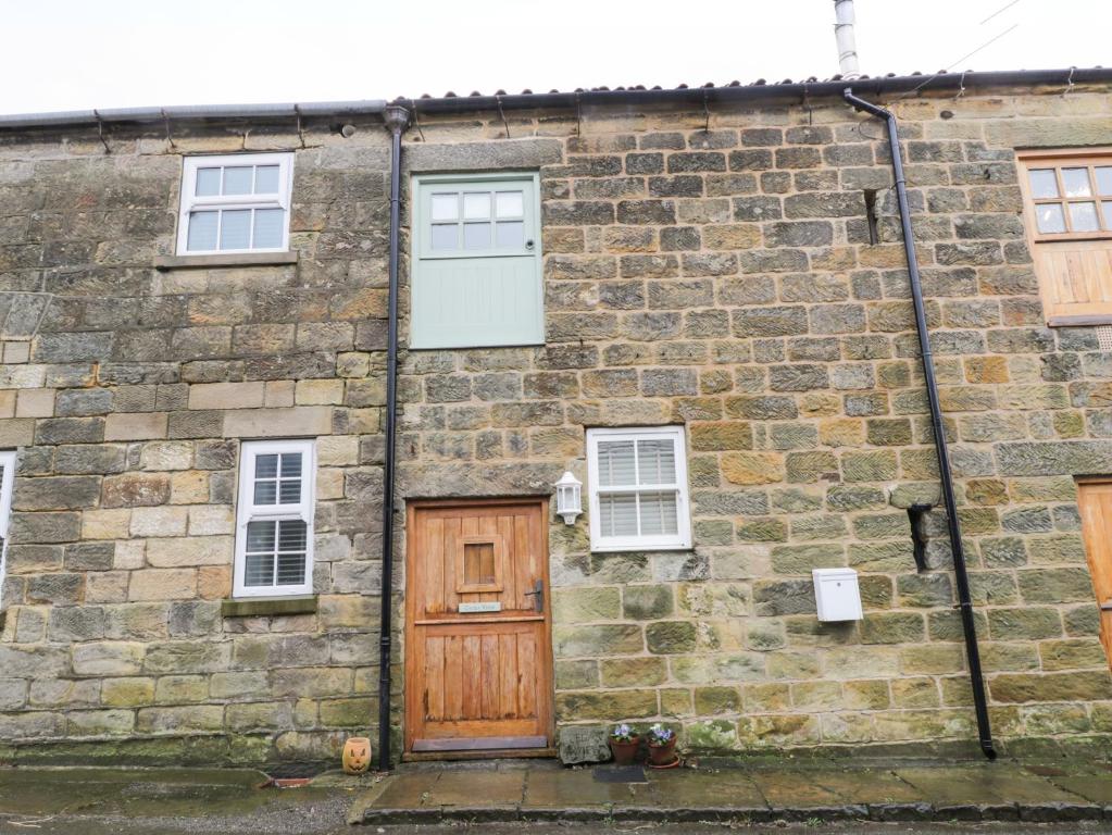 an old stone building with a wooden door and windows at Cedar View in Whitby