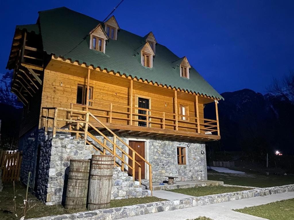 una grande casa in legno con un balcone sopra di Bujtina Vellezerit Grrela a Theth