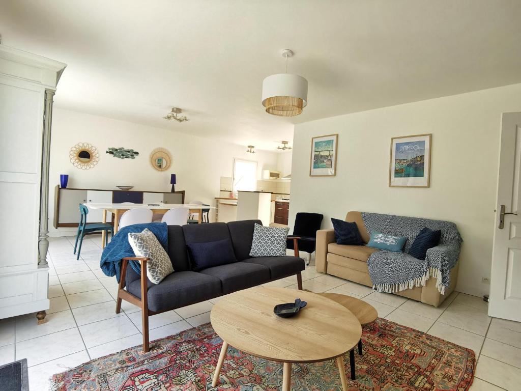 uma sala de estar com um sofá e uma mesa em Gîte de Kerninon Maison spacieuse et lumineuse em Ploulech