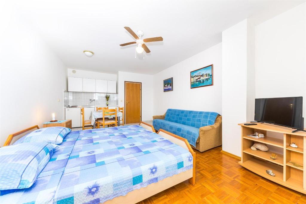 a bedroom with a large bed and a couch at Apartments Val in Vinišće