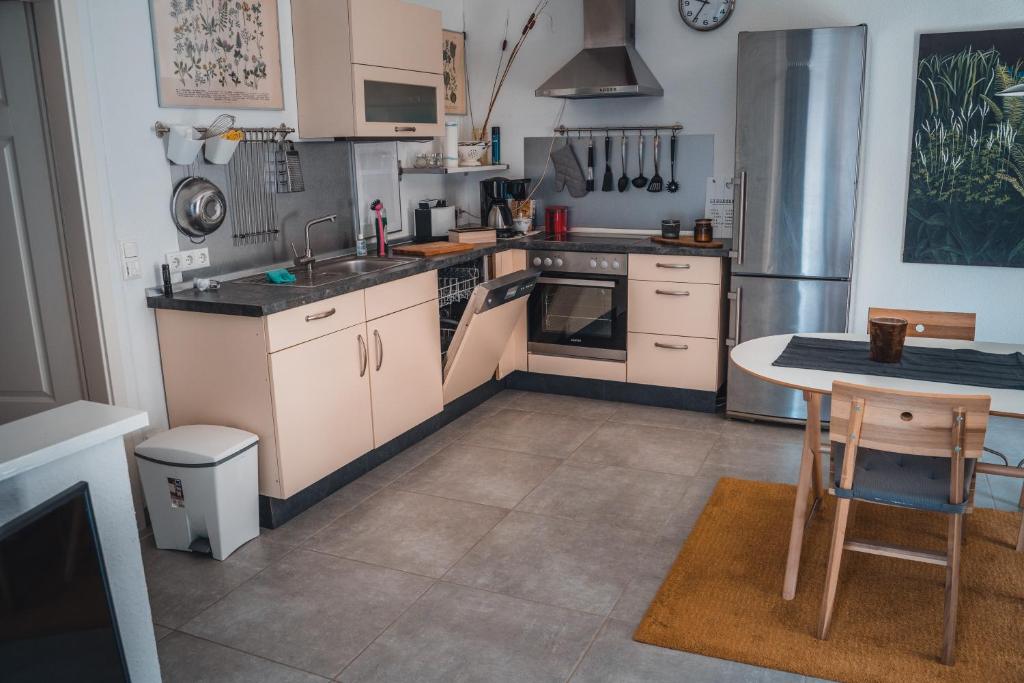 una cocina con armarios blancos y una mesa. en Ferienwohnung in Jülich, nähe Aachen & Köln, en Julich