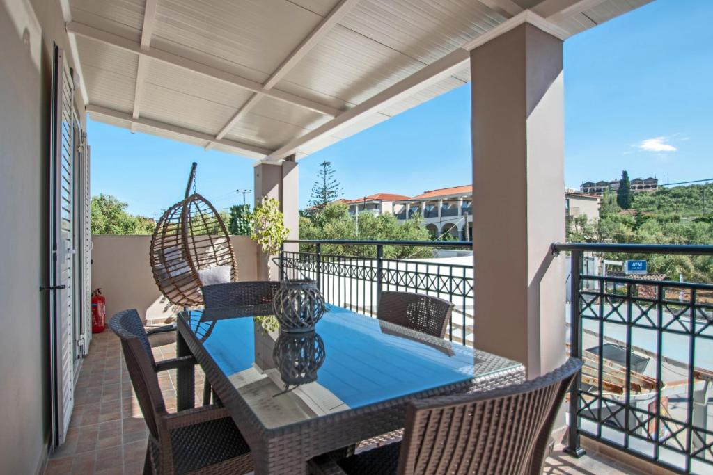 eine Terrasse mit einem Tisch und Stühlen auf dem Balkon in der Unterkunft Tina's Suite in Planos