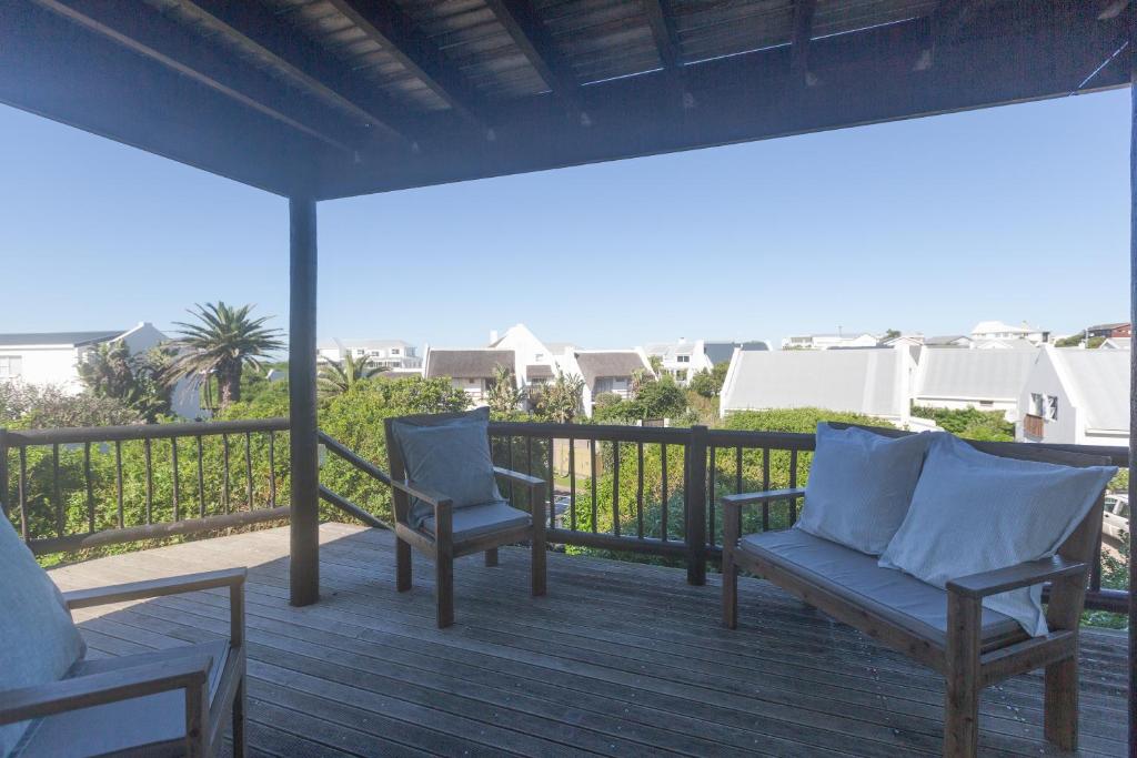 two chairs on a deck with a view of the ocean at Oyster Catcher in Cape St Francis
