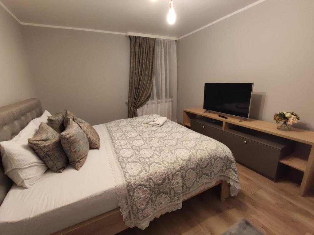 Schlafzimmer mit einem Bett und einem Flachbild-TV in der Unterkunft MAGIC LUX APARTAMENT HUNEDOARA in Hunedoara
