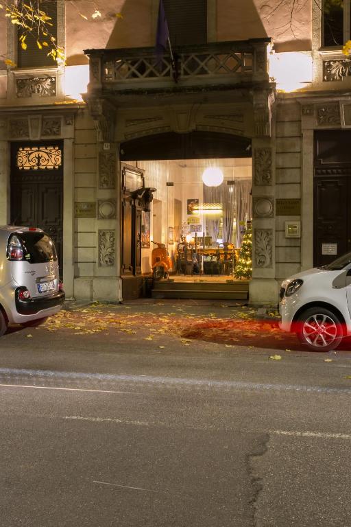 dwa samochody zaparkowane przed budynkiem w obiekcie The Leoncino Hotel w mieście Brescia