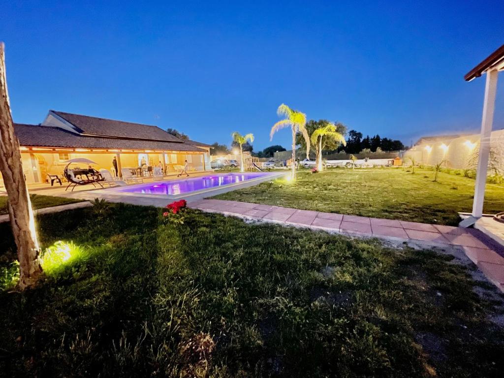 a house with a swimming pool at night at Villa Nunzia con piscina, sauna e idromassaggio. in Floridia